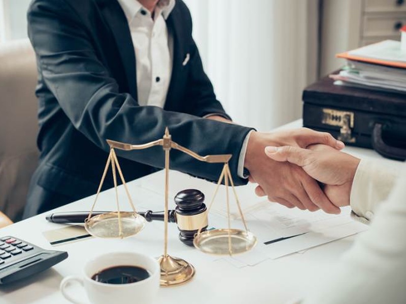 businessman shaking hands to seal a deal with his partner lawyers or attorneys discussing a contract