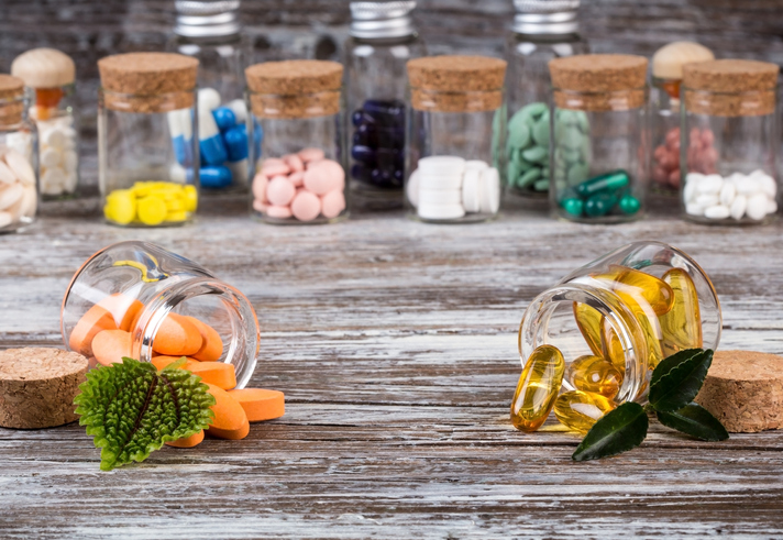 alternative medicines with green leaves in glass containers