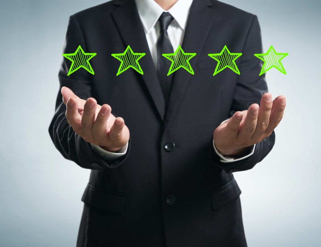 businessman holding five star rating.
